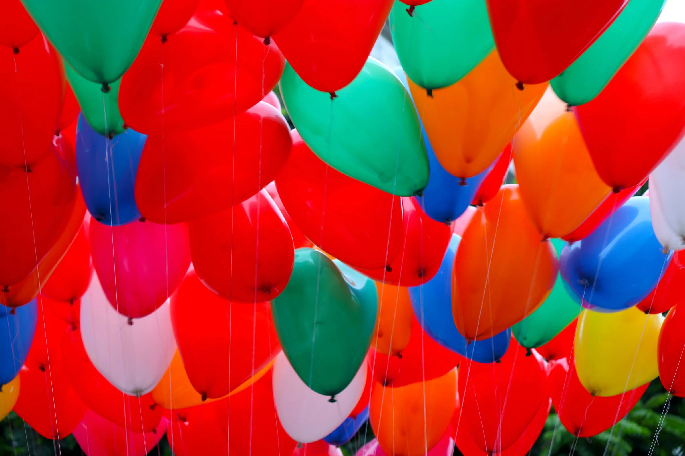 Ceiling of red balloons with green, blue and orange accents