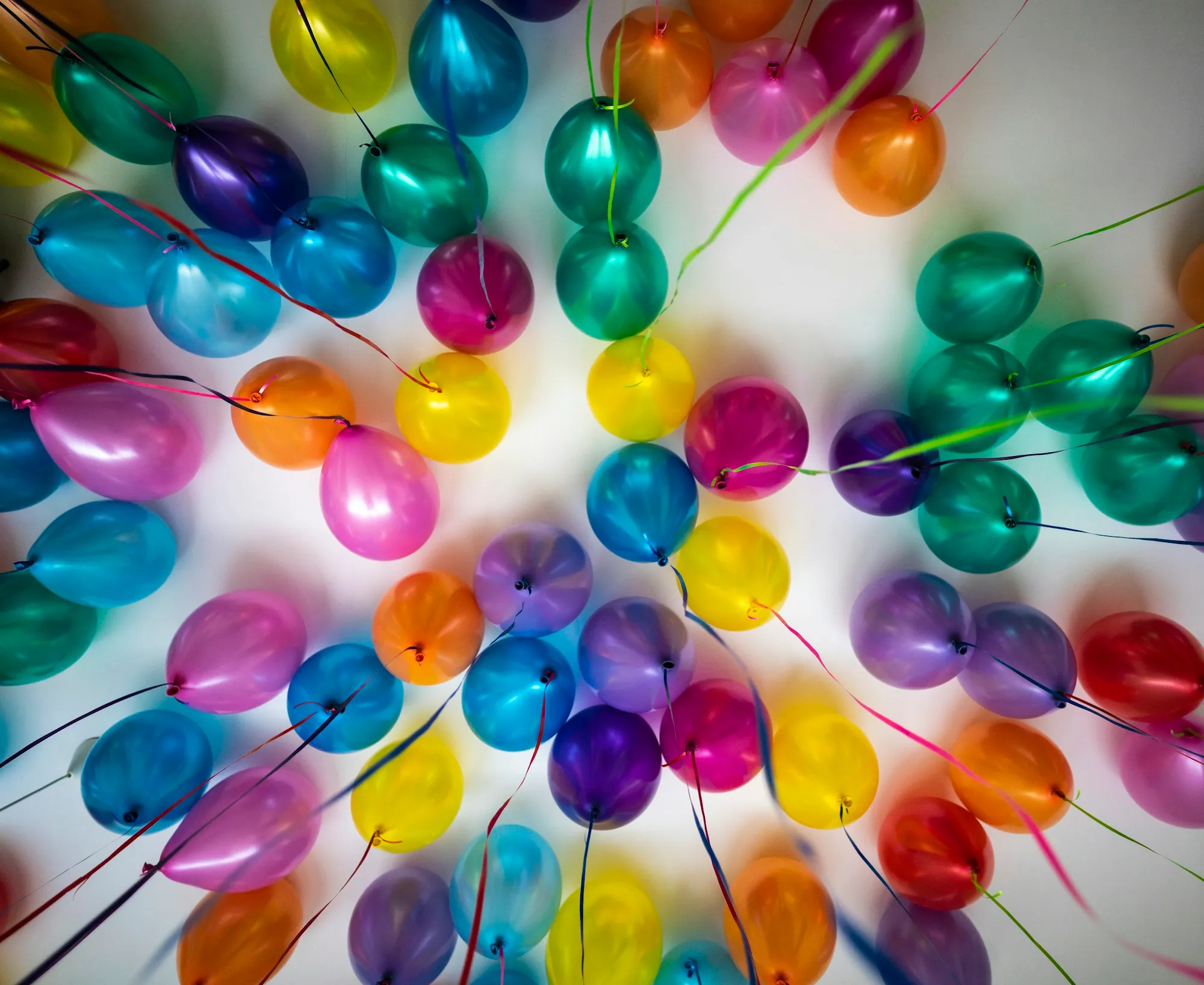 Looking up into dozens of colorful balloons