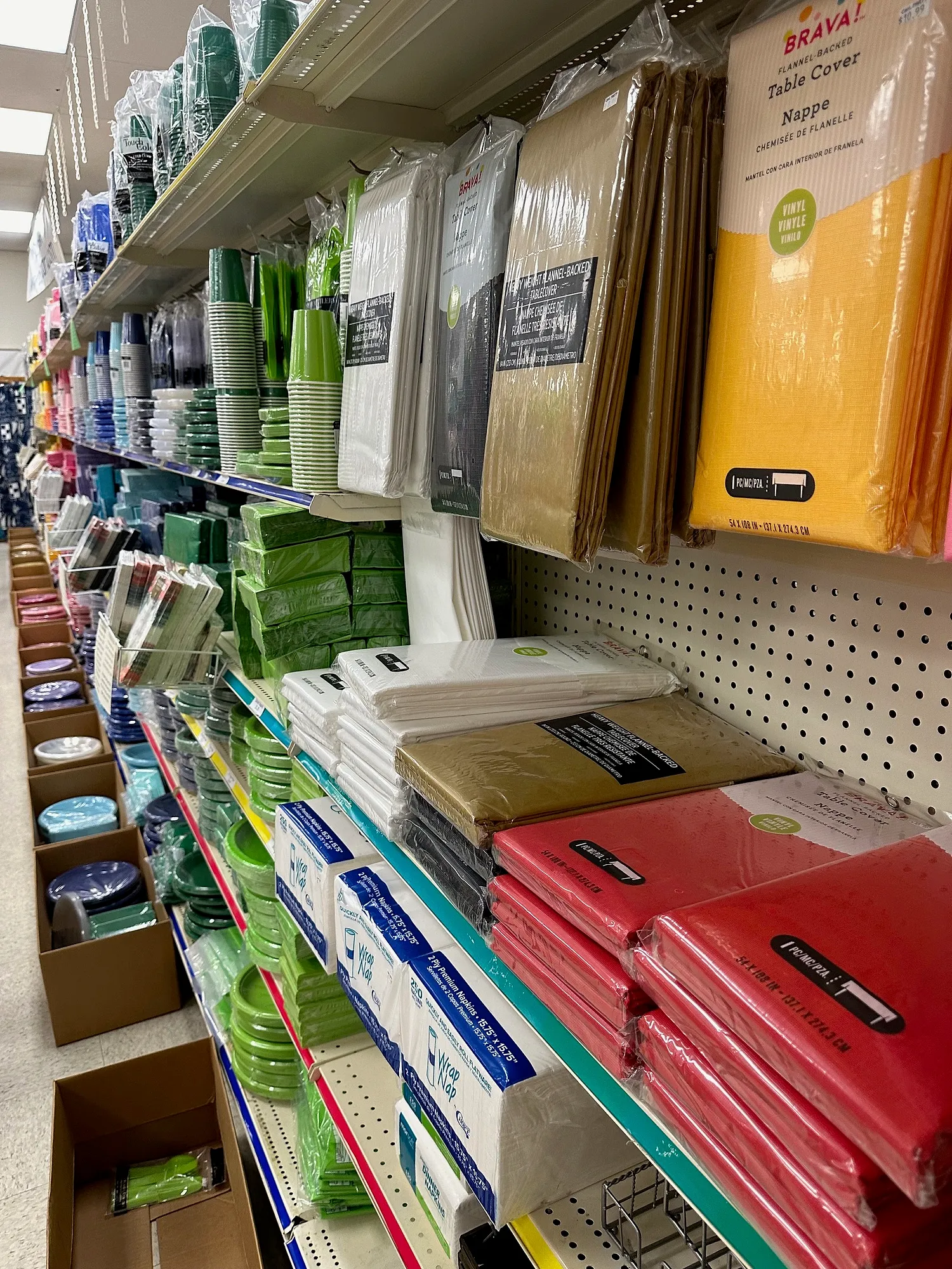 Tableware aisle stocked with solid-color table covers, plates and cups