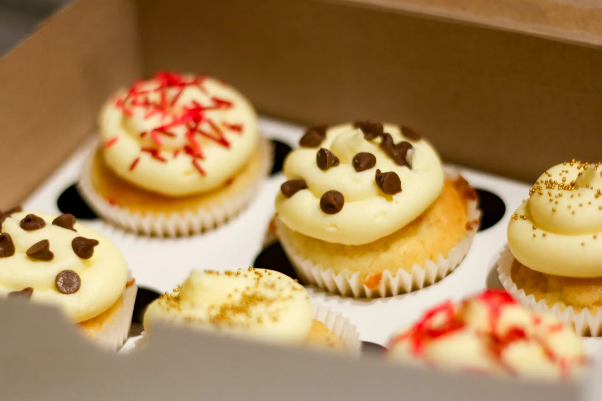 Frosted cupcakes in a kraft cupcake box with an insert