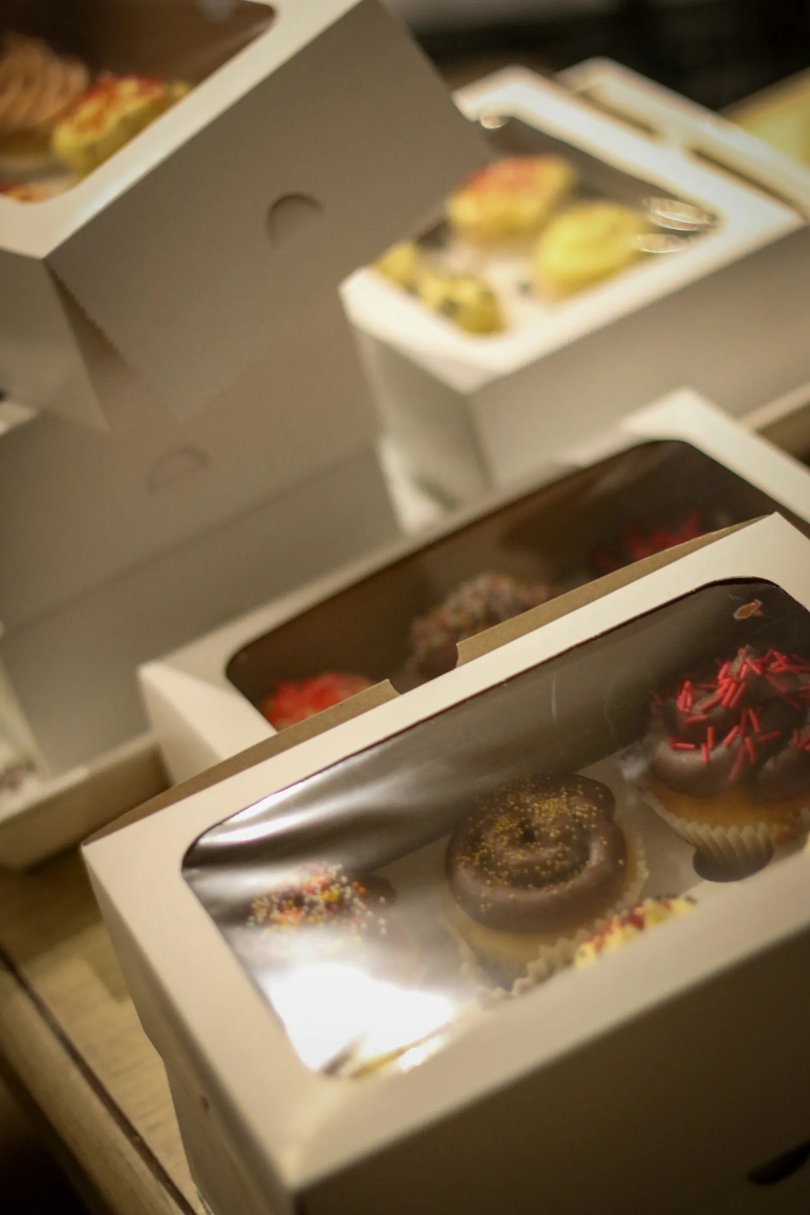 Stack of white window bakery boxes filled with treats