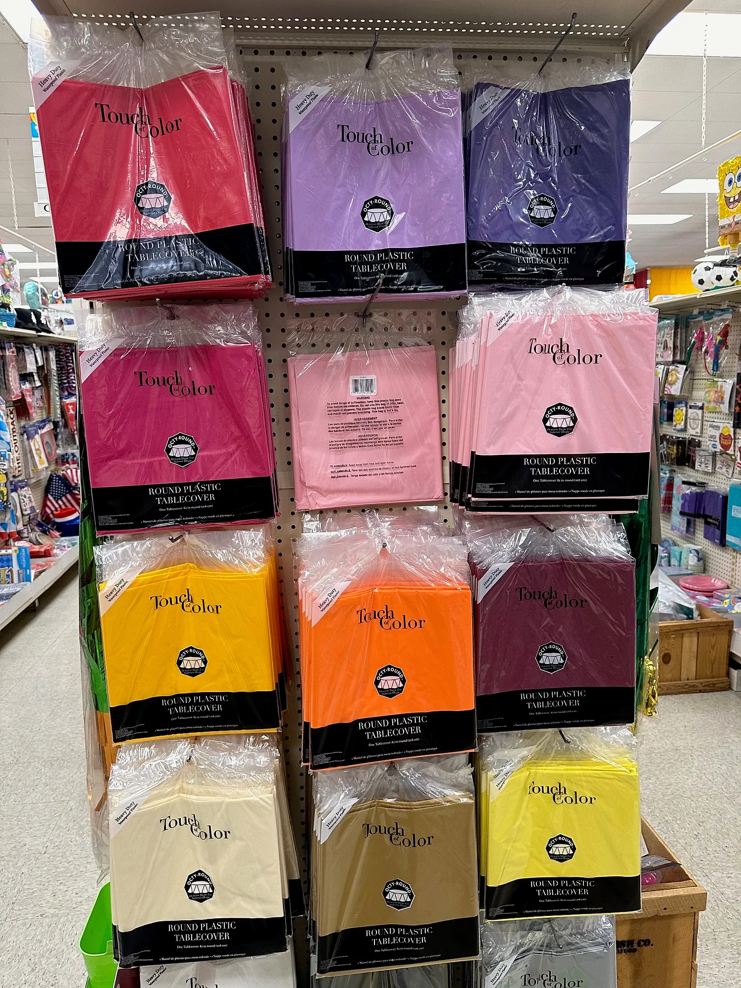 Rack of solid-color plastic table covers inside Capt. Party