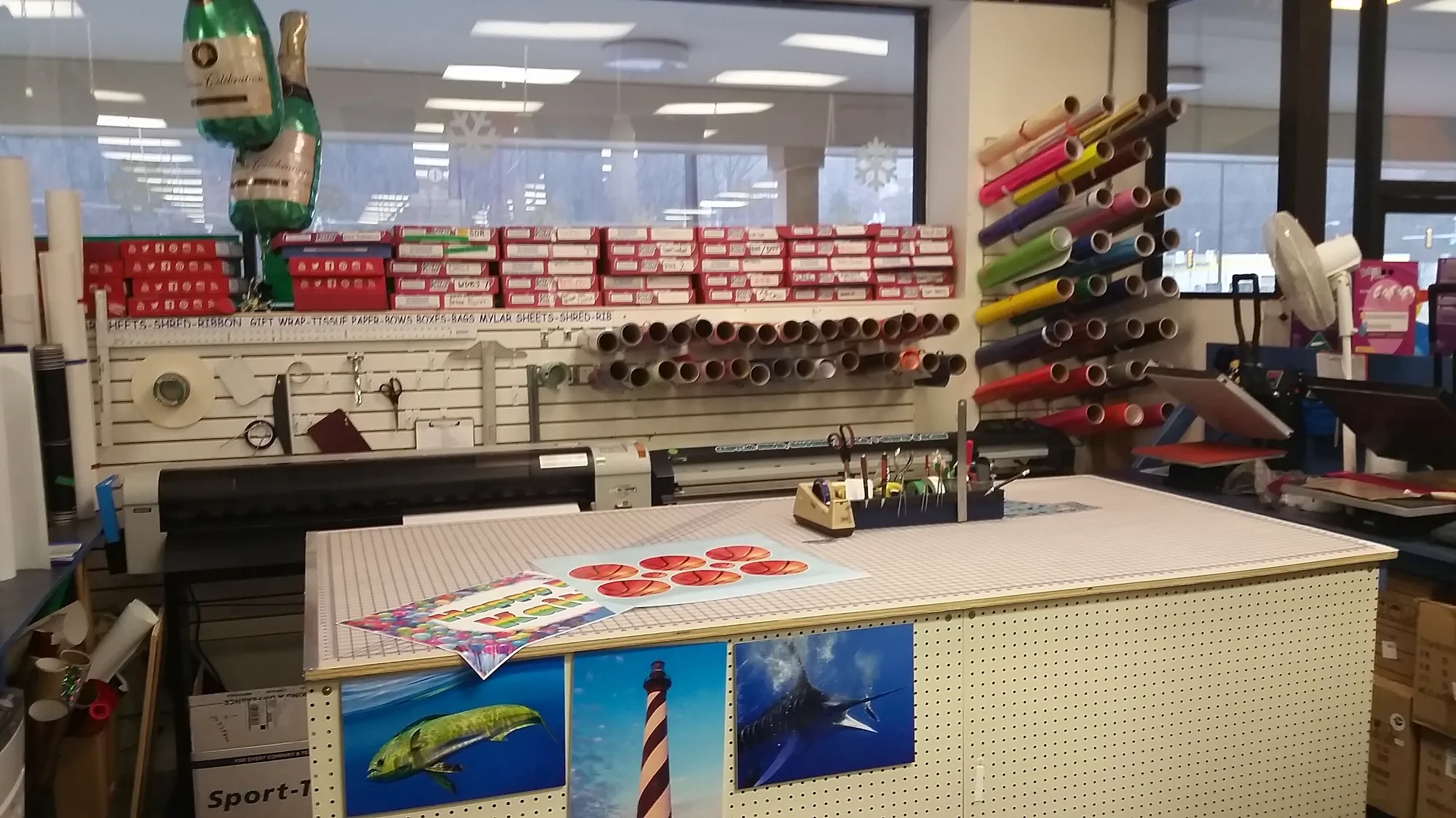 CP Signs and Graphix print room at Capt. Party with a wide-format printer and rolls of vinyl